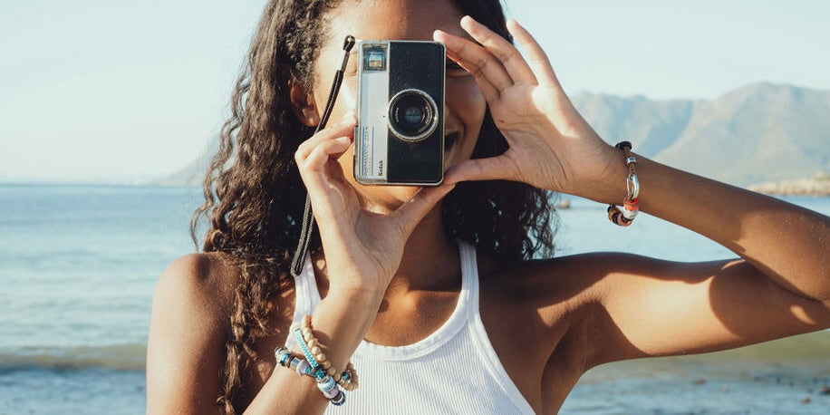 El Camino Bracelets model on beach with camera wearing 2 bracelets