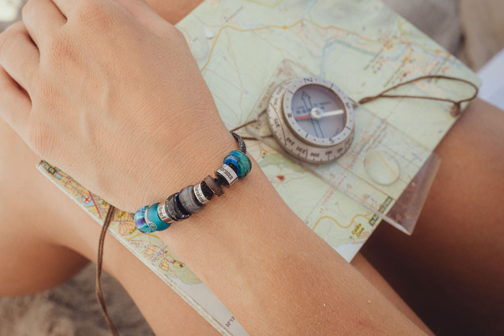 El Camino travel bracelet with Brazil, Blue Northern Lights, Pacific Ocean, Starry Sky, Dolphin, Barcelona, Morocco and Underwater charm Steps memory beads.
