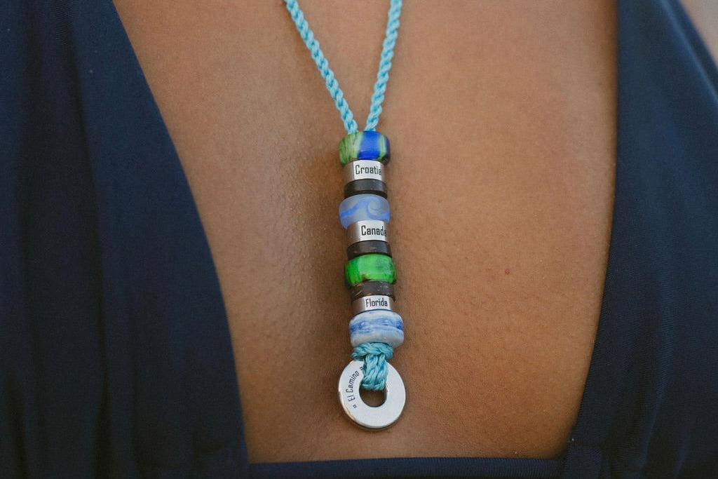 Turquoise El Camino Necklace with travel memory charms on including Canada, Croatia, Florida, Earth, Red Sea, Whale and Green Northern Lights Steps